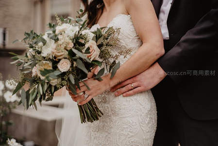 新郎环抱新娘手捧花亲密合影