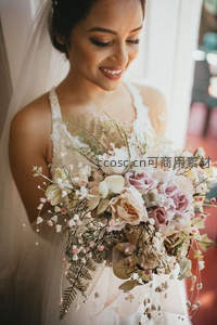 新娘低头凝视粉色系花束