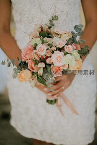 新娘手捧柔美粉色玫瑰花束，蕾丝婚纱尽显温柔