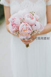 新娘怀抱粉嫩芍药花束，纯白礼服衬托娇艳花朵