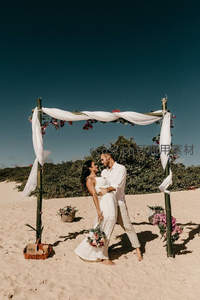 沙滩婚礼拱门下甜蜜对视