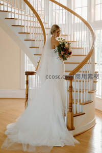 新娘倚靠旋转楼梯，婚纱飘逸如梦