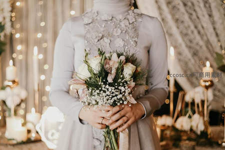 烛光下新娘怀抱精致婚礼花束