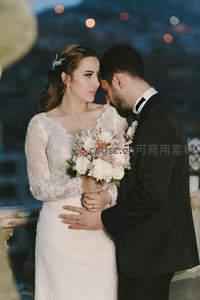 新婚夫妇深情相拥，夜色灯光浪漫温馨