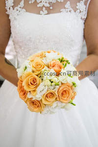 新娘手持橙白玫瑰花束，优雅绽放