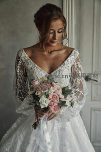 室内新娘低头凝视花束，柔光映衬优雅气质