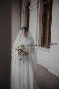 戴面纱新娘静立古典建筑旁