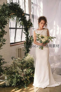 阳光下新娘静立花环旁