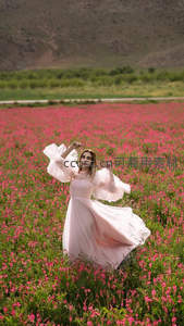 粉裙少女舞动于花海，山野间绽放的浪漫诗篇