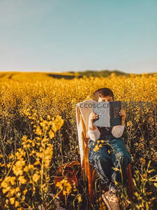 油菜花田中静读，金色海洋里的书香时光