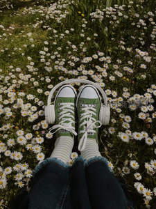 戴着耳机躺卧雏菊丛中享受音乐