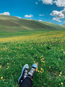 脚踏青草仰望蓝天白云