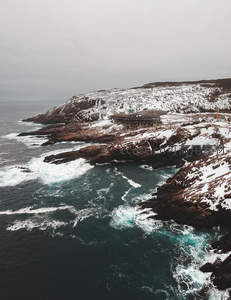 雪覆海岸峭壁与怒涛拍岸奇景