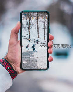 手持手机记录雪地行人，冬日街景尽收屏幕