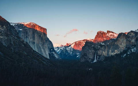 峡谷晨曦，雪山峰顶染上玫瑰金辉