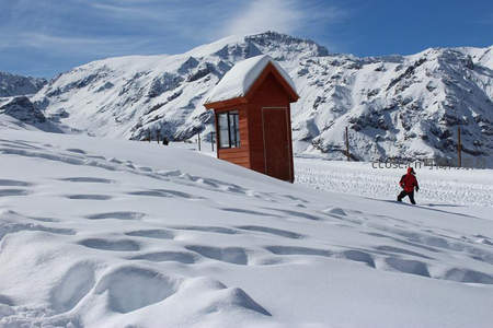 雪地小屋旁孩童奔跑嬉戏