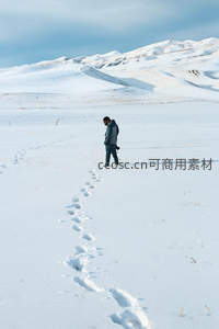 孤独旅人踏雪前行留下长长足迹