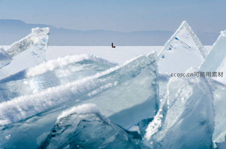 冰棱前景中远眺雪原上孤独身影