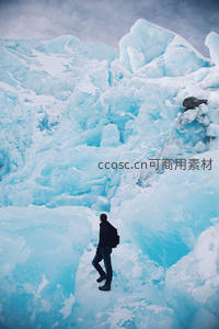 探险者穿行于蓝色冰川峡谷