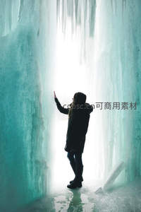 人影触摸冰洞内透射的神秘光芒