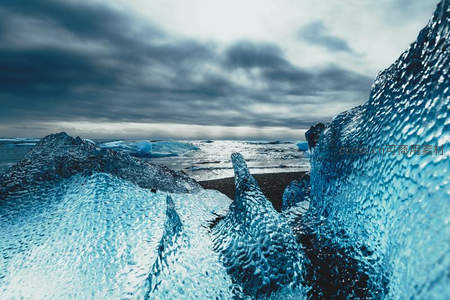 冰川巨块矗立，风暴云下透出幽蓝光泽