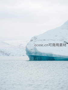 巨大冰山漂浮海面，雪顶蓝底映衬苍穹