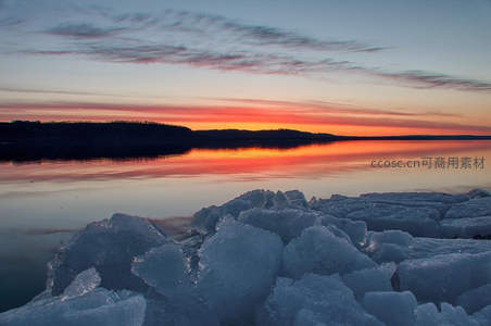 冰封湖面映霞光，冬日黄昏静谧美