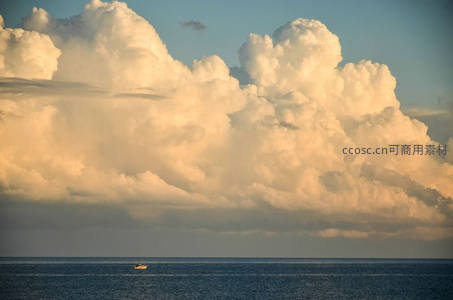 金色云层下海面孤舟的静谧景象