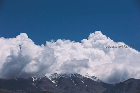 白云如絮覆盖巍峨雪山之巅