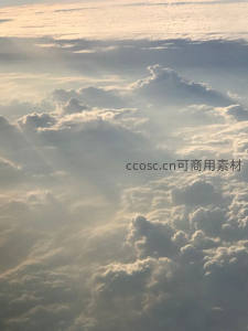 航拍视角下的云海，阳光穿透云隙洒下金辉