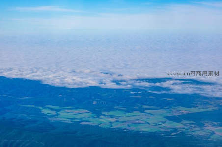 云端俯瞰大地，绿野与森林交织成画