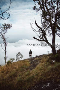 孤影伫立山巅，凝望脚下浩渺云海与苍穹