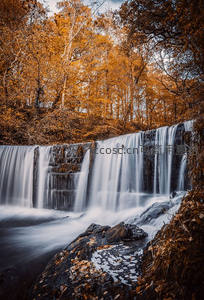 秋日森林瀑布如丝绸般倾泻而下