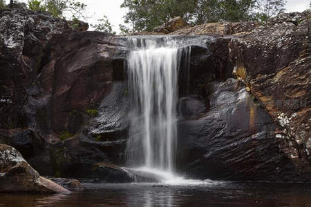 岩石间细瀑轻柔流淌如丝带垂落
