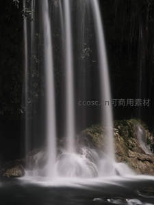 幽暗洞穴中多股瀑布如银线垂落