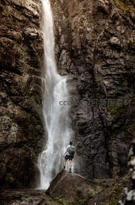 勇者立于巨岩之上仰望悬崖瀑布