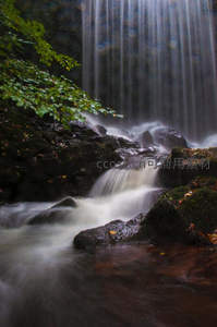 深林瀑布光影交错，水流绕石如烟似雾