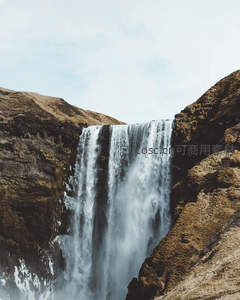峡谷巨瀑如银练垂落，山色苍茫映碧空