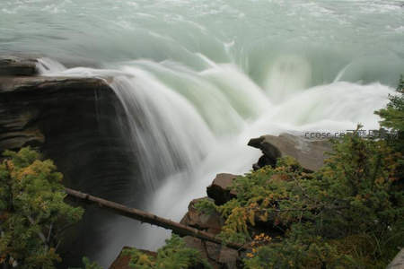 湍急水流冲击岩石的瀑布特写