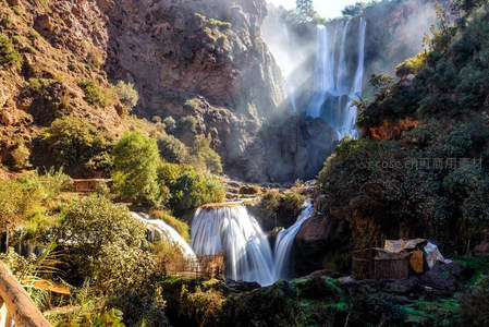 阳光穿透峡谷照亮多级瀑布