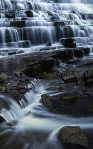 层叠瀑布流泻于幽暗岩石之上