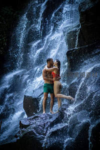 情侣相拥亲吻于奔腾瀑布前