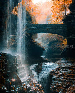 秋日古桥跨峡谷，瀑布如帘映彩林