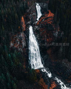 航拍视角下，森林深处双瀑倾泻而下