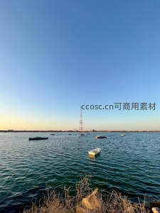 碧水蓝天下的孤舟与远方铁塔