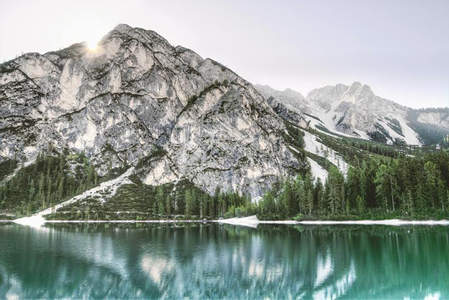阳光洒落雪峰，湖面倒影如梦似幻