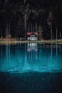 深林湖心小屋，碧水如镜倒影清晰