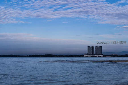 高楼矗立水岸，蓝天白云相映