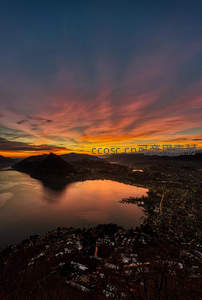 日落霞光染湖面，山城灯火初上时