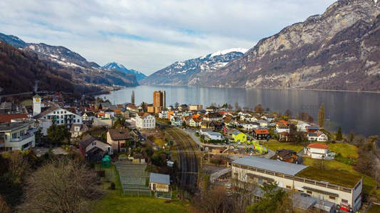 湖畔山城航拍全景，雪峰环抱宁静小镇
